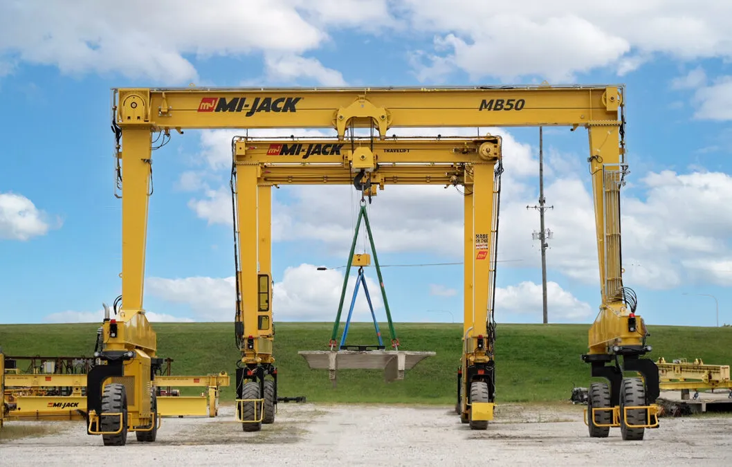 Single Beam gantry Crane doing a tandem lift of a concrete slab with a Travelift RTG Crane