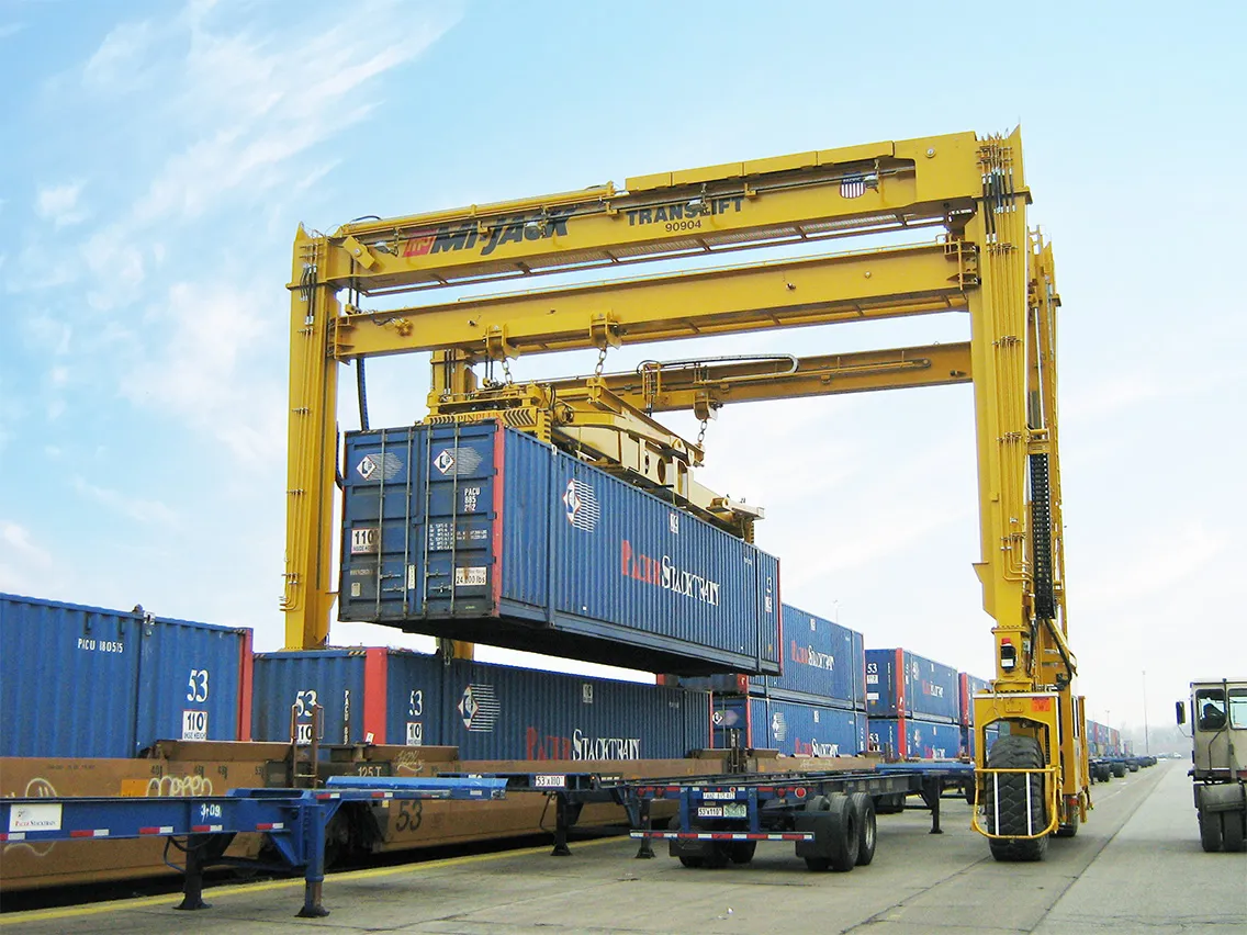 yellow mi-jack 1200r translift lifting a blue container