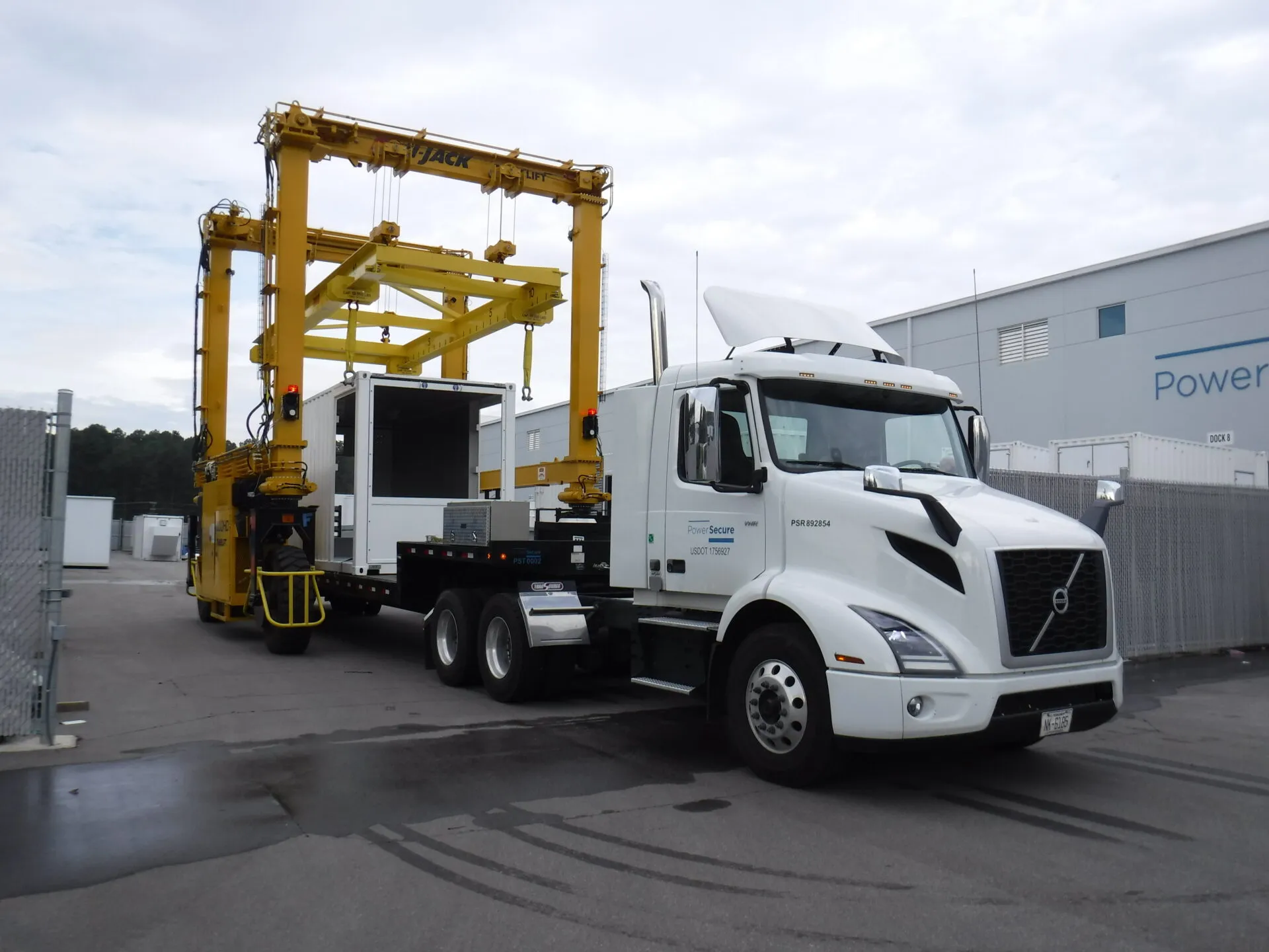 a mi-jack mj30hd uses custom attachment to lift container off truck