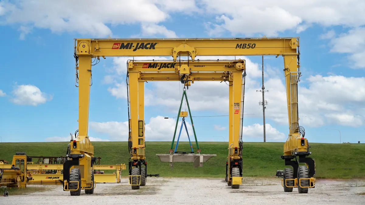 two yellow mi-jack monobeams doing a tandem lift