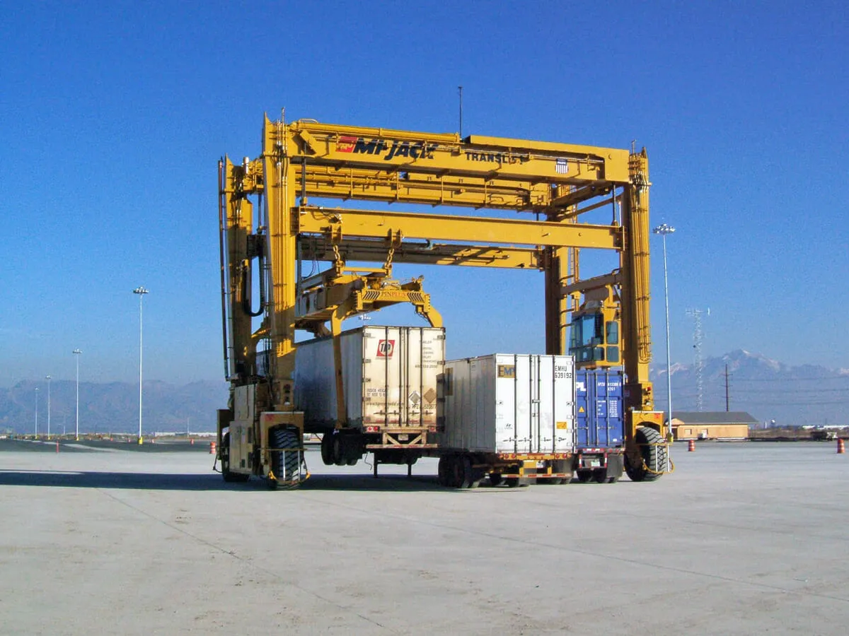 a yellow mj1200r translift crane lifting a container