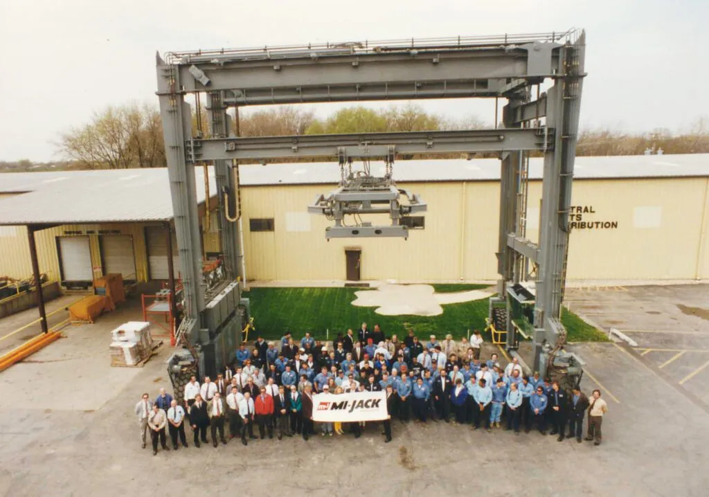 The Mi-Jack team poses in front of a RTG crane at their manufacturing plant in Hazel Crest Illinois