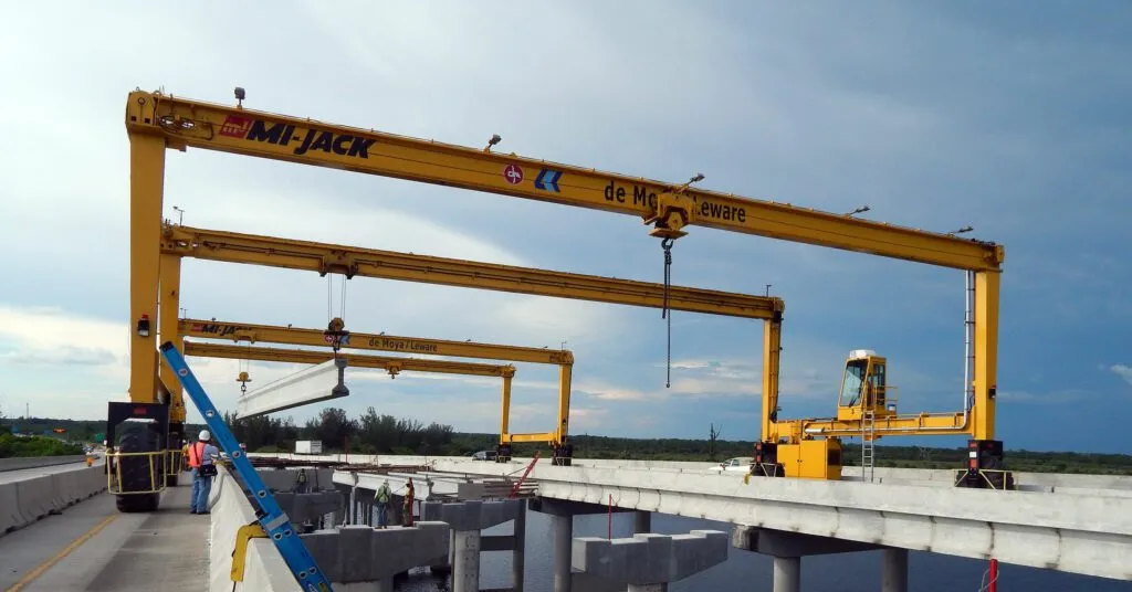 yellow mi-jack travelift crane spanning two bridges