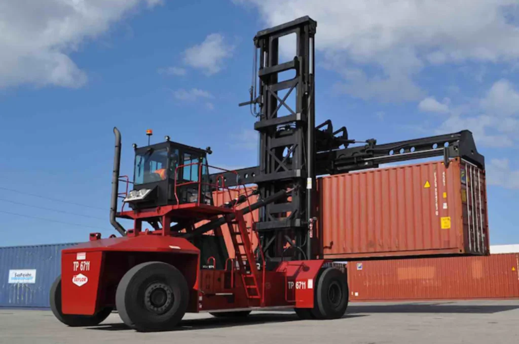 an image of a red taylor container handler lifting orange container